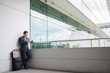 Businessman using digital tablet while waiting for the departure at the airport